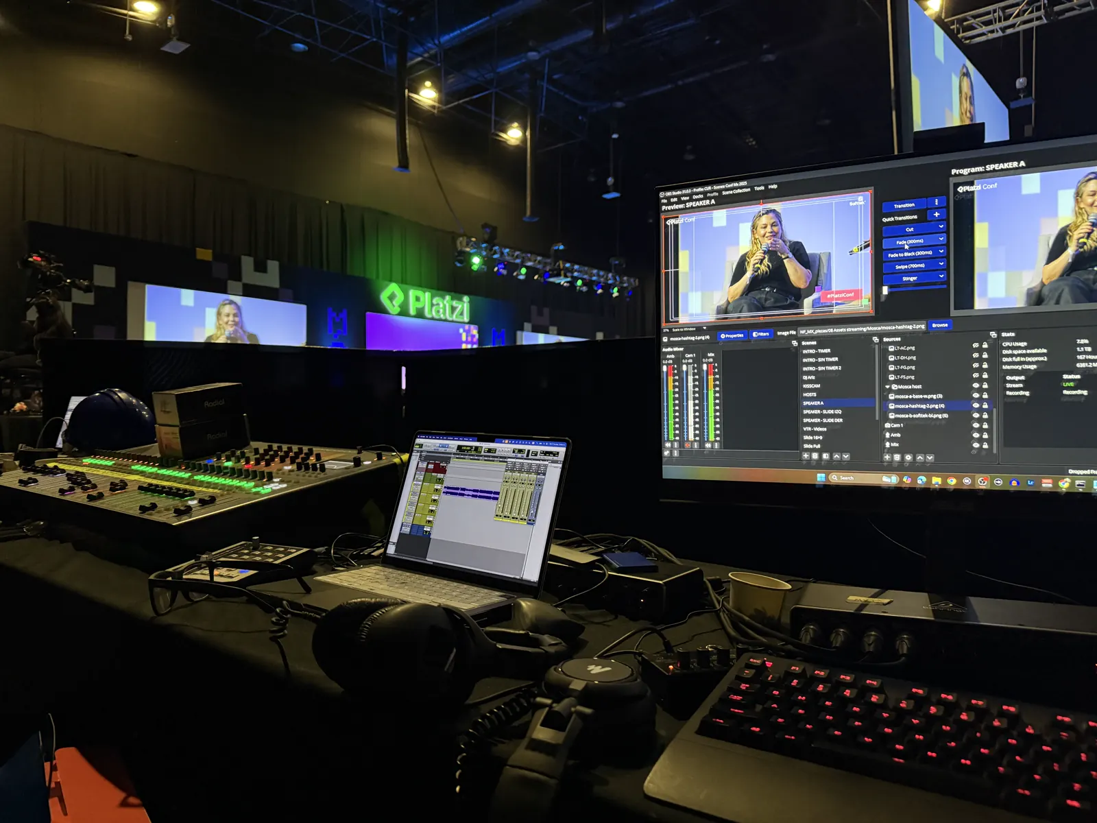 Cabina de Platzi Conf: consola de audio, monitores de programa y computadora.